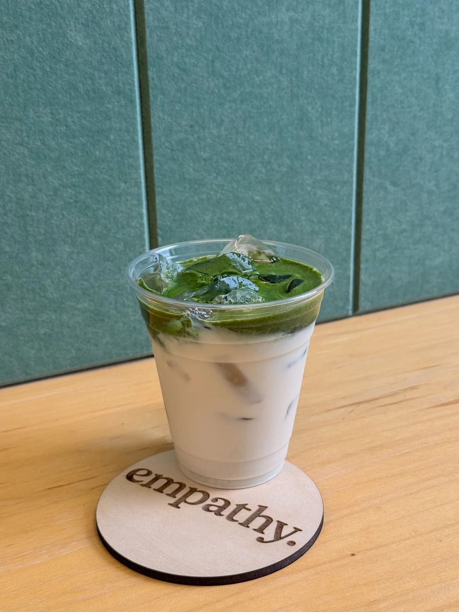 Iced matcha latte served on a custom-branded coaster at a corporate wellbeing event
