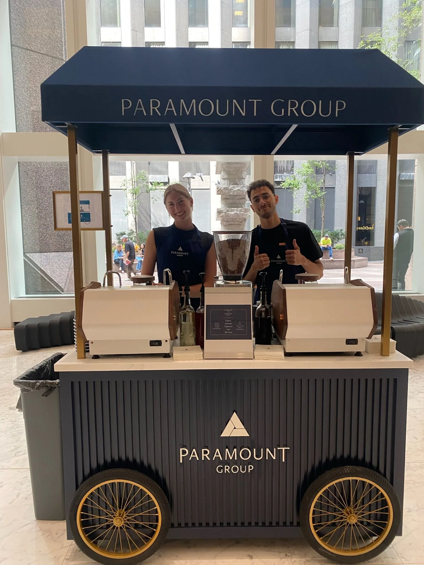Baristas serving from a custom-branded Paramount Group coffee cart at a New York corporate event